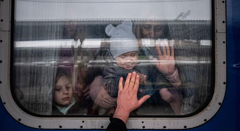 In Kharkiv, Ukraine, a man places his hand to the window of a train car as he says goodbye to his wife and children before they depart on a special evacuation train.