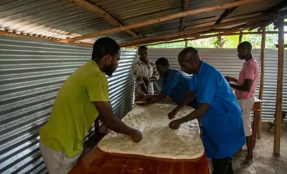 Kavugwa Shebulike Cadet (right) prepares dough with his employees and trainees at his bakery in Nyankanda refugee camp. Kavugwa Shebulike Cadet (right) prepares dough with his employees and trainees at his bakery in Nyankanda refugee camp.