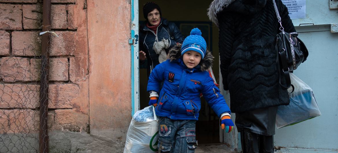 A family receives winter clothing kits for children and other supplies from UNICEF in the frontline community of Marhanets, Ukraine. (file).